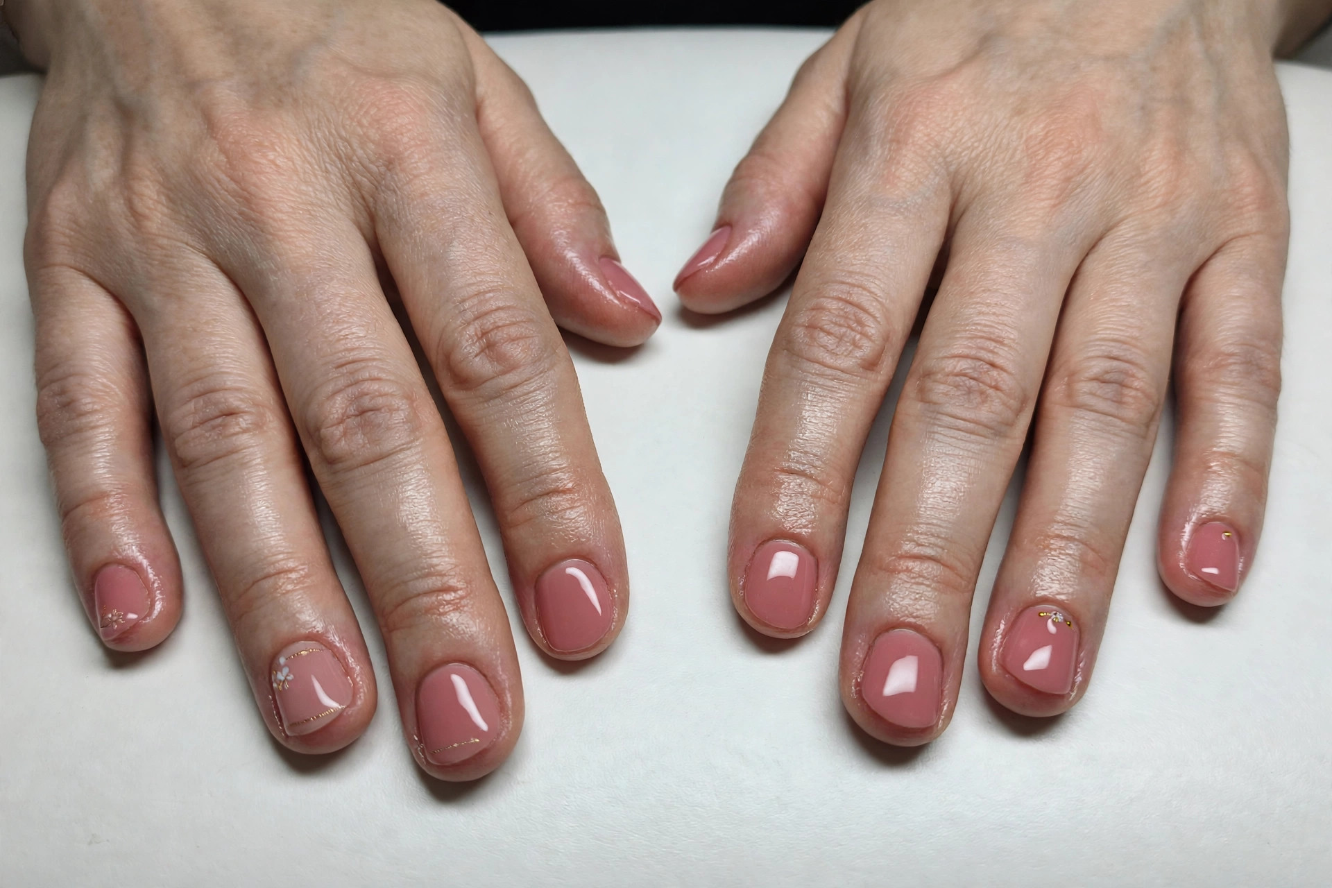 Same hands with elegant glossy manicured nails after treatment